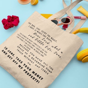 May include: A beige canvas tote bag featuring black printed text that reads: You won, Jane. Enjoy the money. I hope it makes you happy. Dear Lord, what a sad little life, Jane. You ruined my night completely so you could have the money and I hope now you can spend it on lessons in grace and decorum. Because you have all the grace of a reversing dump truck without any tyres on. So Jane, take your money and get off my property!