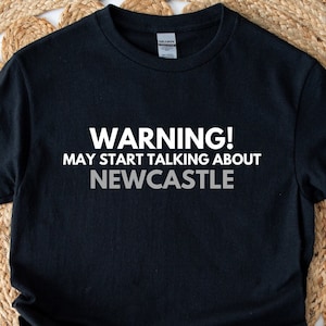 May include: Black t-shirt with white text that reads "WARNING! MAY START TALKING ABOUT NEWCASTLE".