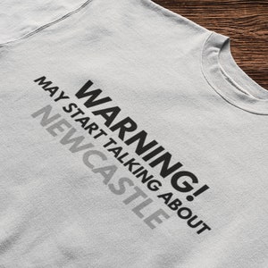May include: A gray sweatshirt with the text "WARNING! MAY START TALKING ABOUT NEWCASTLE" printed on the front.