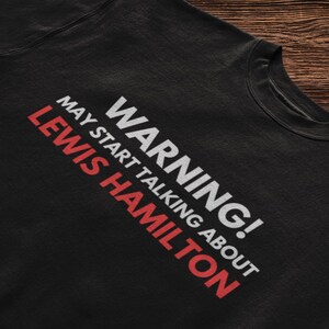May include: Black sweatshirt with white text that reads "WARNING! MAY START TALKING ABOUT LEWIS HAMILTON".