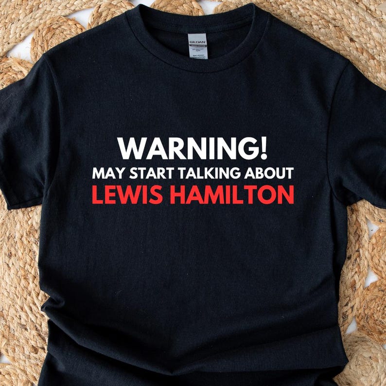 May include: Black t-shirt with white text that reads "WARNING! MAY START TALKING ABOUT LEWIS HAMILTON".