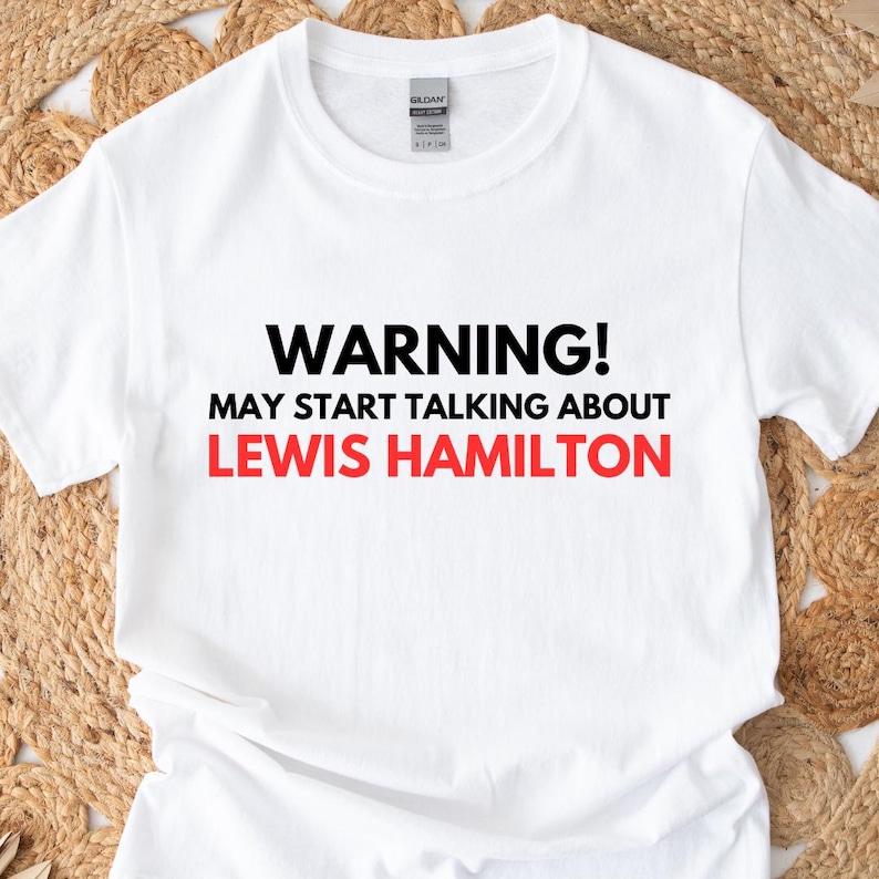 May include: White t-shirt with black text that reads "WARNING! MAY START TALKING ABOUT LEWIS HAMILTON".