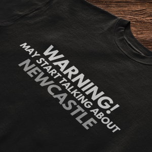 May include: Black t-shirt with white text that reads "WARNING! MAY START TALKING ABOUT NEWCASTLE".
