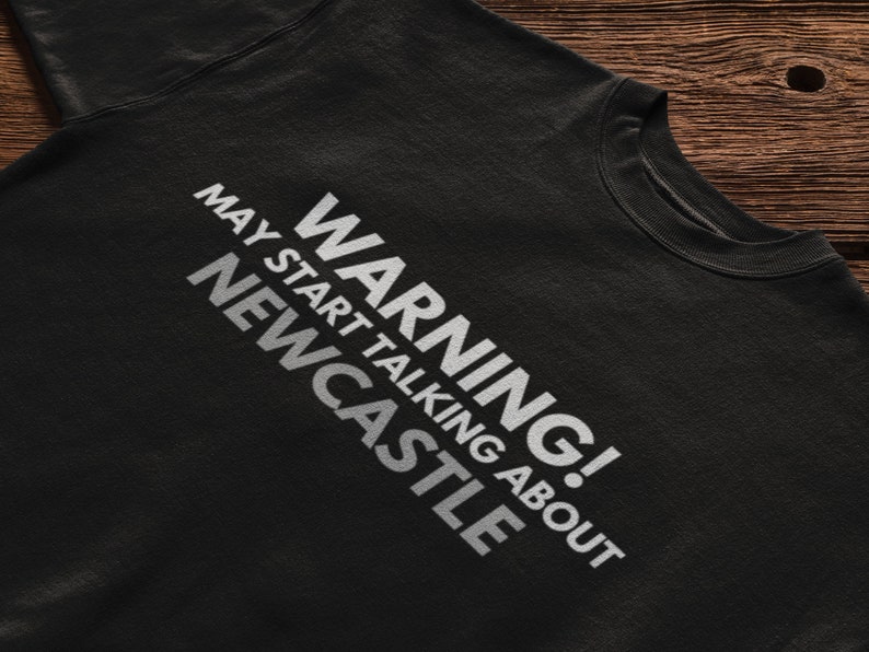 May include: Black t-shirt with white text that reads "WARNING! MAY START TALKING ABOUT NEWCASTLE".