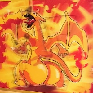 May include: A Thicc Charizard Pokémon card featuring an orange and yellow dragon illustration. The card has text including "Thicc Charizard 120 HP" and "Fire Ring" attack details. The card's design includes a stage 2 evolution indicator.