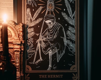 May include: A black and white tarot card illustration of The Hermit. The card features a skeletal figure wearing a hooded robe and holding a lantern. The figure is surrounded by stylized foliage and stars.