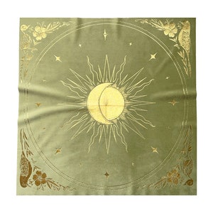 Pu&ograve; includere: Un arazzo di velluto verde con un designo di sole e luna dorati. Il sole e la luna sono circondati da piccole stelle dorate. L'arazzo ha un bordo dorato con motivi floreali e di uccelli.