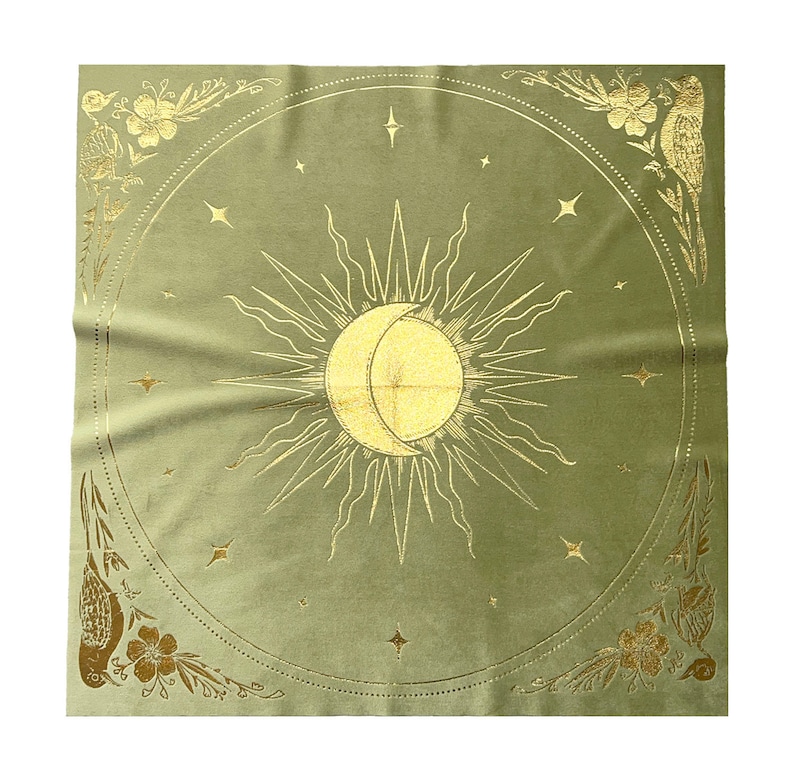 Pu&ograve; includere: Un arazzo di velluto verde con un designo di sole e luna dorati. Il sole e la luna sono circondati da piccole stelle dorate. L'arazzo ha un bordo dorato con motivi floreali e di uccelli.