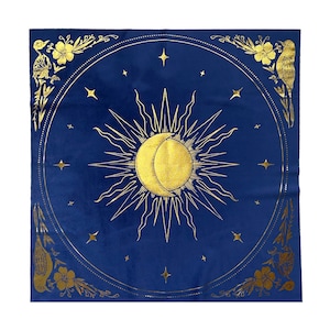 Pu&ograve; includere: Un arazzo quadrato blu con un designo di sole e luna dorati. Il sole e la luna sono circondati da un cerchio di stelle dorate. L'arazzo ha un bordo dorato con disegni floreali e uccelli.