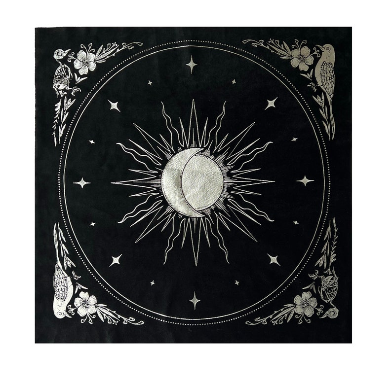 May include: Black tapestry with a silver sun and moon design surrounded by stars and floral accents. The tapestry has a border of birds and flowers.