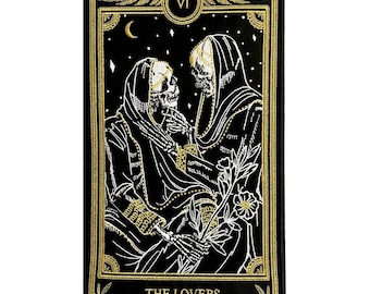 May include: Black tarot card patch featuring an illustration of two skeletal figures in cloaks, holding hands. The card is framed with gold accents and the text "THE LOVERS" is at the bottom. The card also has the Roman numeral "VI".