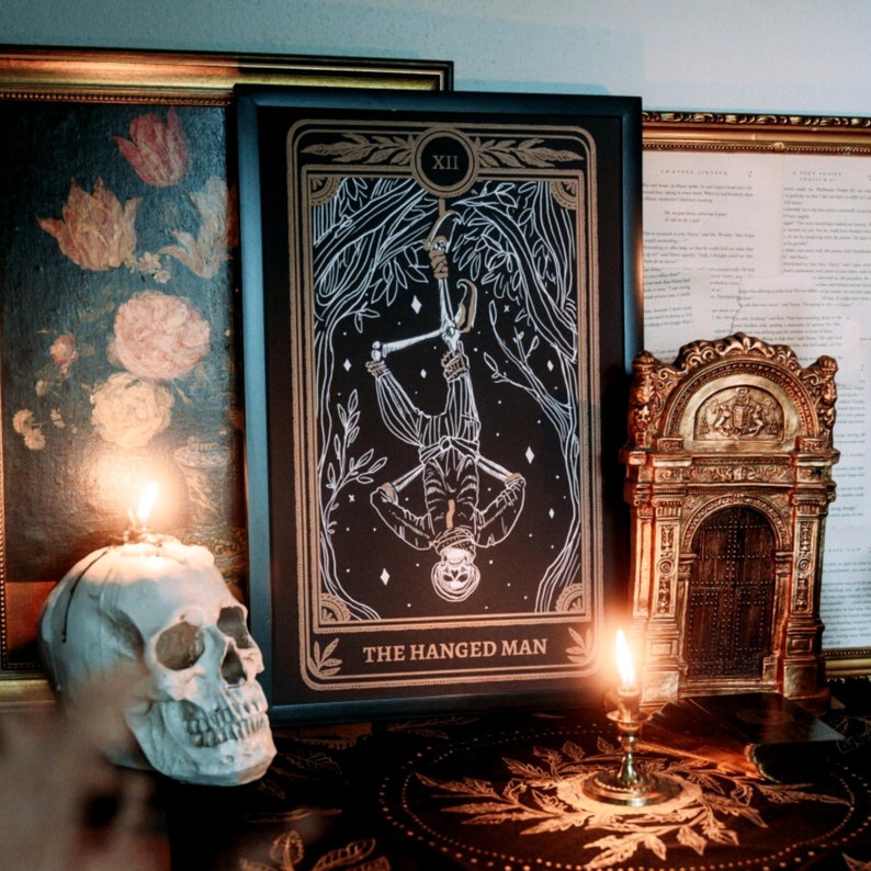 the hanged man tarot print on altar with altar cloth, skull, and candle. Design from the Marigold Tarot deck