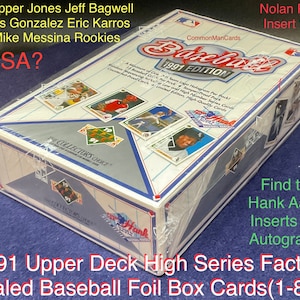 May include: A sealed box of 1991 Upper Deck High Series Factory baseball cards. The box is white with blue and red accents. The front of the box features a baseball card of Nolan Ryan, a baseball card of Chipper Jones, and a baseball card of Jeff Bagwell. The box also features the text "1991 Edition" and "The Collector's Choice".