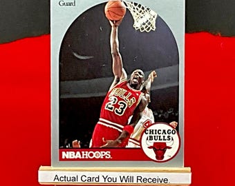 1990-91 NBA Hoops Michael Jordan "MJ" Basketball Card #65 in Nrmt Condition Chicago Bulls HOF class of 2009. Includes Ultra Pro Top Loader