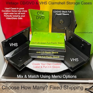 May include: A collection of vintage CD/DVD and VHS clamshell storage cases. The image shows open and closed black and green cases, with text labels indicating CD/DVD and VHS formats. The cases are displayed against a colorful background.