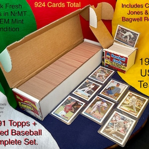 May include: A complete set of 1991 Topps + Traded Baseball cards. The set includes 924 cards in near mint to gem mint condition, with Chipper Jones and Jeff Bagwell rookies. Custom labels are included for decorative display.
