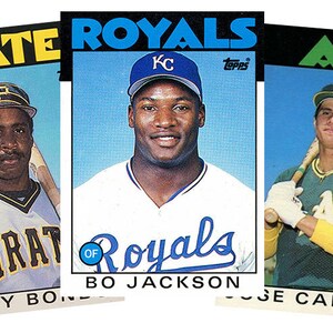 May include: Three baseball cards featuring players from the Pittsburgh Pirates, Kansas City Royals, and Oakland Athletics. The cards are from the 1980s Topps series. The players featured are Barry Bonds, Bo Jackson, and Jose Canseco.