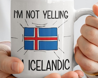 May include: White ceramic mug with a black outline of the Icelandic flag and the text "I'm not yelling I'm Icelandic".