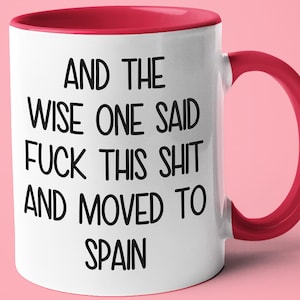 Puede incluir: Taza de cerámica blanca con interior y asa rojos. La taza presenta texto negro que dice "AND THE WISE ONE SAID FUCK THIS SHIT AND MOVED TO SPAIN" sobre un fondo rosa.