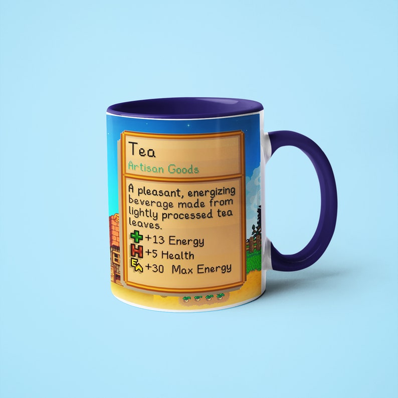 Op de afbeelding: Een blauwe en witte mok met een gepixelde afbeelding van een videogame-item genaamd "Thee". De tekst luidt "Ambachtelijke goederen", "Een aangename, energieke drank gemaakt van licht verwerkt thee-blad." en " +13 Energie", " +5 Gezondheid", " +30 Maximale energie".