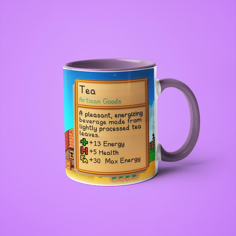 Op de afbeelding: Een paarse en witte mok met een gepixelde afbeelding van een videogame-item genaamd "Thee". De tekst luidt "Ambachtelijke goederen" en beschrijft het item als een "aangenaam, energiek drankje gemaakt van licht verwerkte theebladeren." Het item levert +13 energie, +5 gezondheid en +30 maximale energie.