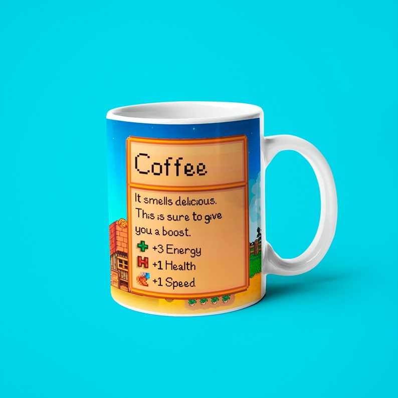 May include: White coffee mug with a pixelated design inspired by the video game Stardew Valley. The mug features a text box with the word "Coffee" and a description of the drink's effects: "It smells delicious. This is sure to give you a boost. +3 Energy +1 Health +1 Speed"