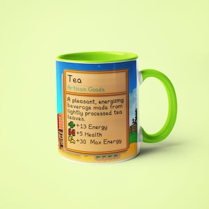Op de afbeelding: Een groene en blauwe mok met een gepixelde afbeelding van een videogame-item genaamd "Thee". De tekst luidt "Ambachtelijke goederen" en beschrijft het item als een "prettig, energiek drankje gemaakt van licht verwerkte theebladeren." De afbeelding toont ook de statistieken van het item: +13 Energie, +5 Gezondheid en +30 Maximale Energie.