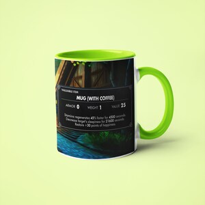 May include: A white ceramic mug with a green rim and handle. The mug features a video game-style graphic of a wooden house with a river in front of it. The text "VALUABLE ITEM MUG (WITH COFFEE) ARMOR 0 WEIGHT 1 VALUE 25 Stamina regenerates 45% faster for 4500 seconds. Decrease target's sleepiness for 21600 seconds. Restore +30 points of happiness." is printed on the mug.