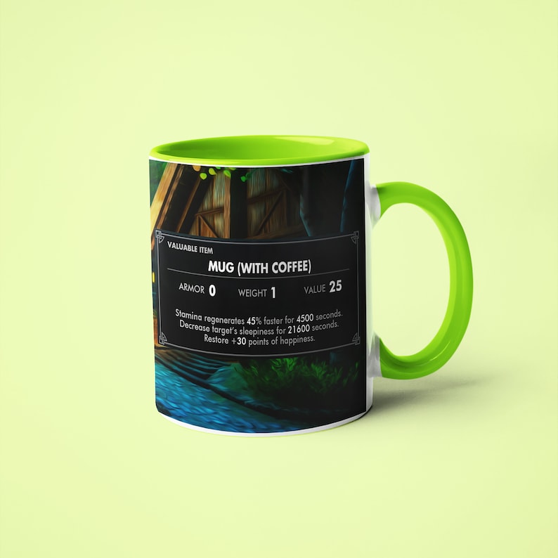 May include: A white ceramic mug with a green rim and handle. The mug features a video game-style graphic of a wooden house with a river in front of it. The text "VALUABLE ITEM MUG (WITH COFFEE) ARMOR 0 WEIGHT 1 VALUE 25 Stamina regenerates 45% faster for 4500 seconds. Decrease target's sleepiness for 21600 seconds. Restore +30 points of happiness." is printed on the mug.