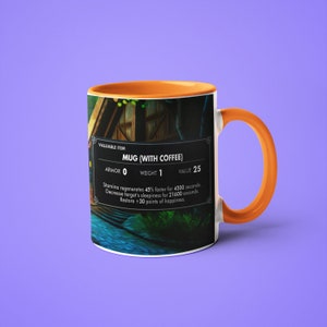 May include: A white ceramic mug with an orange rim and handle. The mug has a video game-style graphic on it that says "MUG (WITH COFFEE)" and has stats like "Armor: 0", "Weight: 1", and "Value: 25".