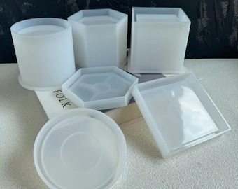 May include: Set of six white silicone molds for crafting. The molds are in various shapes, including a round cylinder, a square, a hexagon, and two different sized round coasters.