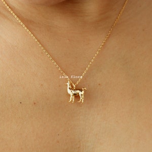 May include: A gold chain necklace with a small gold llama pendant.