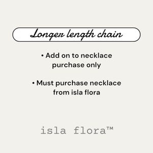 Op de afbeelding: Tekst op een witte achtergrond die "Longer length chain" leest met opsommingstekens en de tekst "Add on to necklace purchase only" en "Must purchase necklace from isla flora" en de tekst "isla flora™".