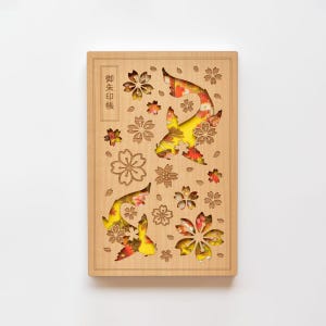 Op de afbeelding: Houten decoratief paneel met uitgesneden koi-karpers en bloemmotieven. De vissen zijn gevuld met gele, rode en oranje patronen. Japanse tekst is zichtbaar aan de linkerkant.