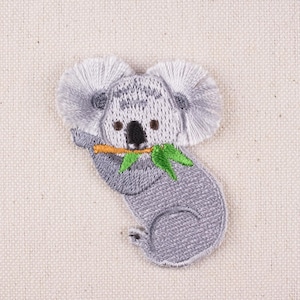 May include: Embroidered iron-on patch of a grey koala holding a green eucalyptus leaf in its mouth.