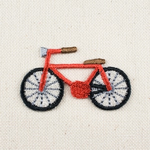 Pode incluir: Patch de bicicleta bordado em vermelho com pneus pretos e raios brancos.