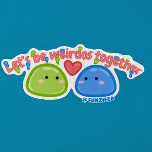 May include: A sticker with the text "Let's be weirdos together" in a playful font. The sticker features two cartoon blobs, one green and one blue, with smiling faces and a red heart between them. The sticker has a white border.
