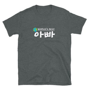 May include: A dark heather grey t-shirt with a white graphic that says "WORLD'S BEST" and a Korean word in white text. The graphic also includes a small image of a blue and green globe.