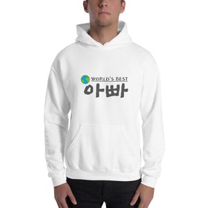 May include: White hooded sweatshirt with a graphic print of a globe and the text "WORLD'S BEST" in black, followed by the Korean text "아빠" in black.