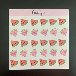 Puede incluir: Hoja de pegatinas de sandía. Cada pegatina presenta una rodaja de sandía con pulpa roja, semillas negras y corteza verde. La palabra "Gabtopia" está impresa en escritura negra en la parte superior.
