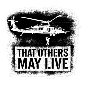 May include: Black and white sticker featuring a helicopter with a person rappelling down. The text "THAT OTHERS MAY LIVE" is in a white rectangular box below the helicopter, with a textured black background.