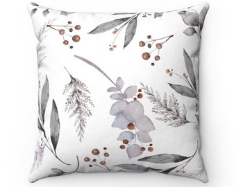 May include: Square cushion featuring a white backdrop adorned with a watercolour design of grey and brown leaves and berries. The cushion's soft, neutral colours make it suitable for a variety of interior design schemes.
