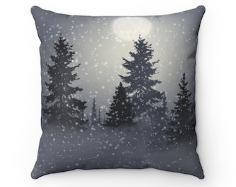 May include: Square cushion with a winter forest design. The image depicts silhouetted fir trees under a full moon, with falling snow. The colour scheme is mainly grey and white, creating a calm, wintry aesthetic.