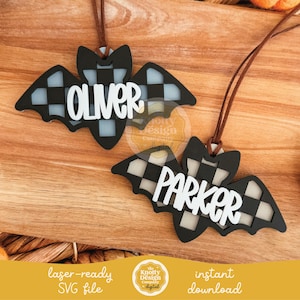 May include: Two black and white checkered bat-shaped ornaments with the names "OLIVER" and "PARKER" in white. Each ornament has a brown string for hanging. The background is a wooden surface. The bottom of the image has text that reads "laser-ready SVG file" and "instant download".
