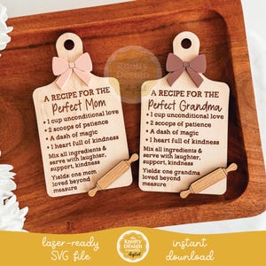 May include: Two wooden cutting board shaped plaques with text, each topped with a bow and a small rolling pin. One reads "A Recipe for the Perfect Mom" and the other "A Recipe for the Perfect Grandma". The plaques are on a wooden tray.