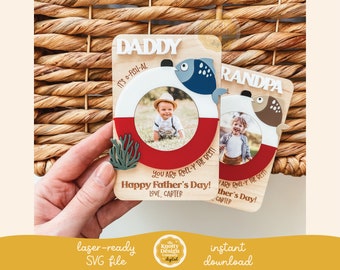 May include: Wooden Father's Day photo frames with a fishing theme. One frame says "Daddy" and the other says "Grandpa". Each frame has a photo opening, a red and white life preserver design, and a fish illustration. The text reads "Happy Father's Day!"