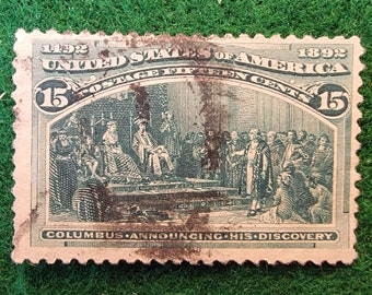 May include: A vintage 15-cent United States postage stamp from 1892, featuring a green illustration of Christopher Columbus announcing his discovery to the Spanish court. The stamp has a worn and faded appearance.