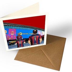 May include: A folded greeting card featuring a cartoon illustration of three people wearing red and blue soccer jerseys with the text DAD 1, MUM 10, and 7 on the backs, standing before a stadium with a sign reading Spotify CAMP.