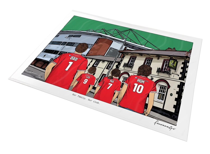 Pu&ograve; includere: Una stampa con illustrazione digitale che mostra quattro persone viste di spalle che indossano maglie da calcio rosse con nomi e numeri. Le maglie riportano DAD 1, LEO 9, MIA 7 e MUM 10. Lo sfondo mostra uno stadio e il testo Our family. Our club.