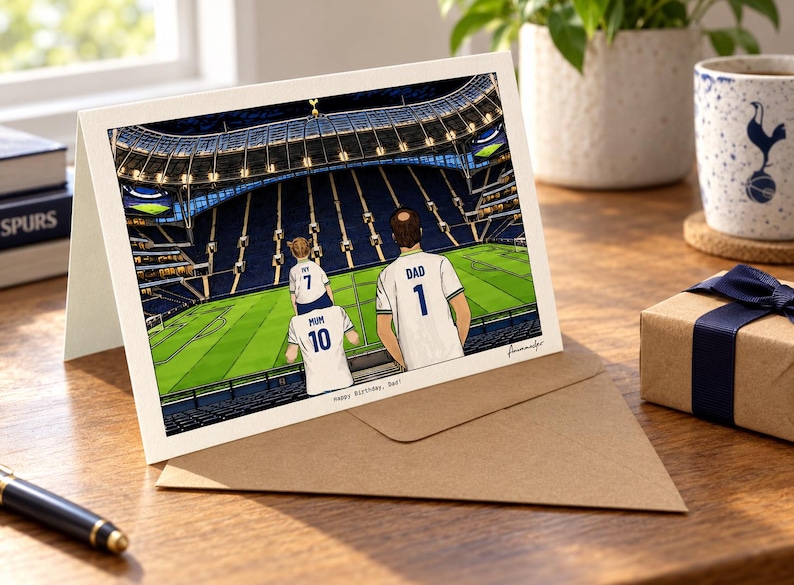 May include: A greeting card featuring an illustration of three people in white soccer jerseys with the numbers 1, 7, and 10, and the names DAD, IVY, and MUM on their backs, standing in a stadium. The text Happy Birthday, Dad is printed below.